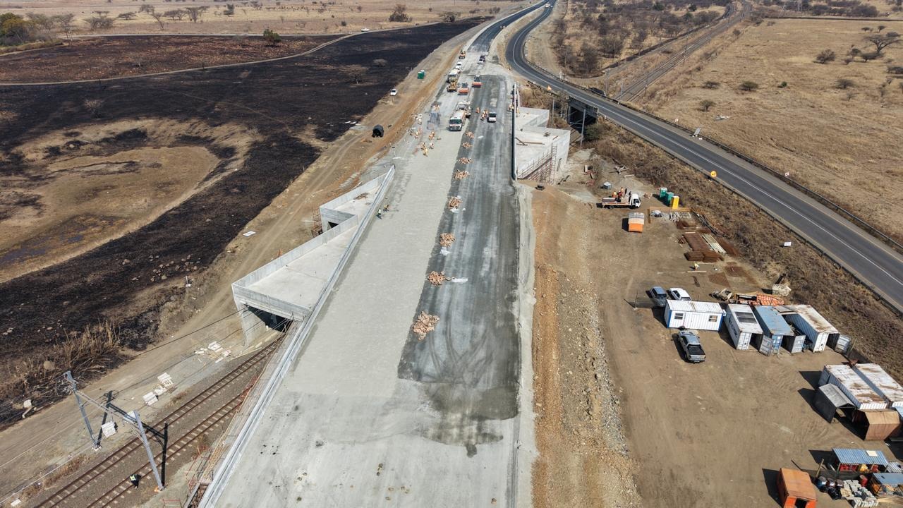 Aerial view of a concrete bridge deck under construction beside a highway