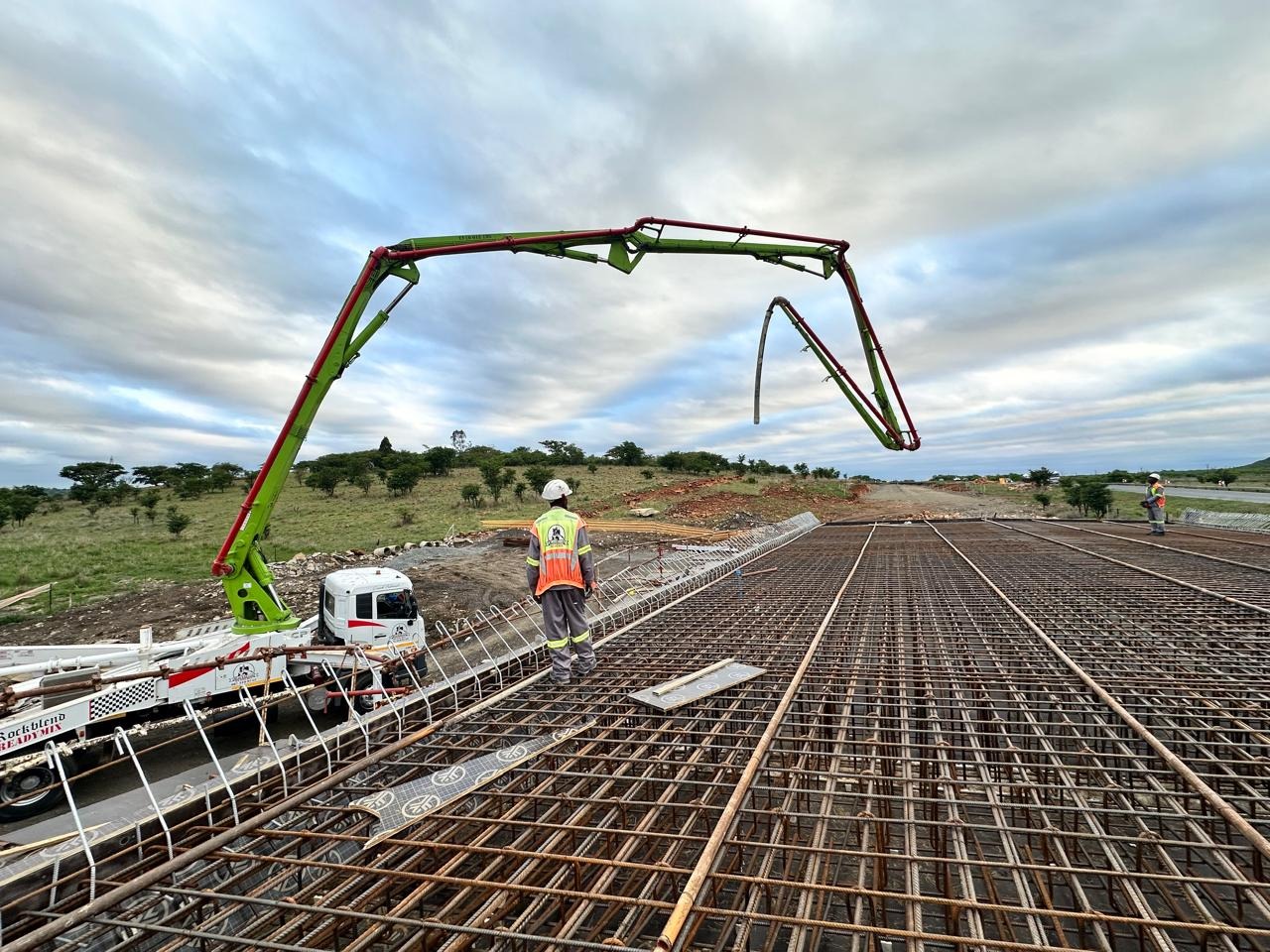 Concrete pump placing a reinforced deck with a supervisor in a high-visibility vest